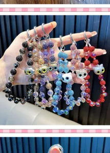 Détail de divers charmes de tête de chat perlés de strass colorés pour clés et sacs à main