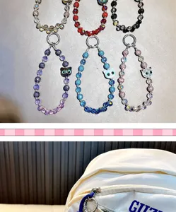 Détail de divers charms de tête de chat en perles de strass colorées sur un sac à dos blanc