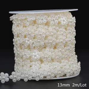 Close-up view of cream white ABS faux pearl flower trim chain on a white spool