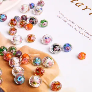 Detailed macro shot of faceted lampwork beads with floral patterns and gold foil