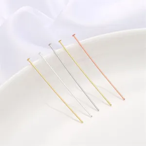 Close-up of assorted gold-plated T-pins for DIY jewelry making in various finishes