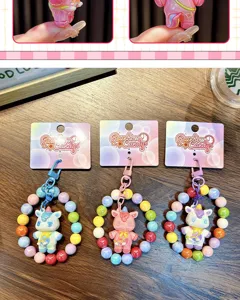 Detailed macro view of colorful beaded unicorn keychains with Rainbow Candy branded packaging cards