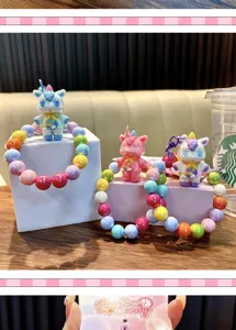 Close-up of three colorful beaded unicorn keychains on display blocks for phone charms