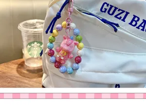 Close-up of a cute beaded pink unicorn charm attached to a white backpack