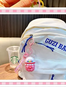 Dettaglio di un portachiavi a forma di tè boba con orsetto rosa su uno zaino bianco