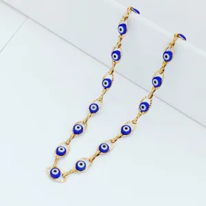 Detailed macro view of a gold plated stainless steel necklace with blue evil eye beads