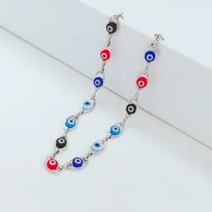 Detail view of colorful evil eye beads on a stainless steel chain necklace