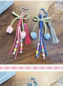Close-up of bohemian tulip flower keychain with braided tassels and heart-shaped carabiner