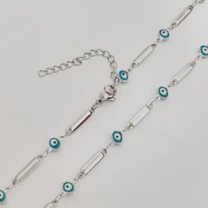 Detail showing evil eye charms and cylindrical links on stainless steel necklace