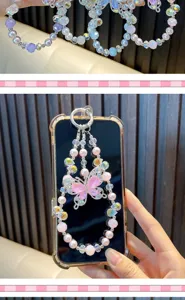 Close-up detail of a pink crystal butterfly beaded phone charm with pearls.