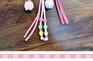 Close-up of pink woven cords and colorful beads of a tulip flower keychain
