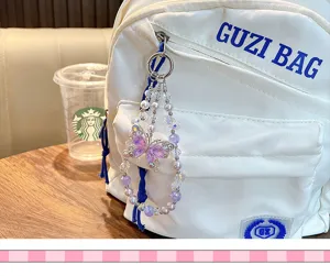 Detail of purple crystal butterfly beaded pendant hanging on a white backpack