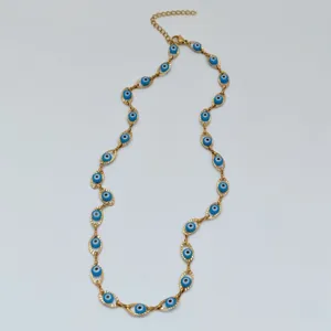 Close-up view of a gold stainless steel necklace with multiple blue evil eye charms.