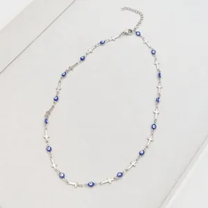 Detailed view of silver stainless steel necklace with blue evil eye beads and crosses
