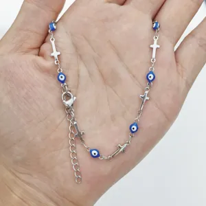 Detailed macro view of the stainless steel cross and blue enamel evil eye beads necklace