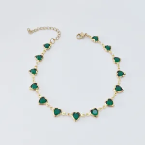 Elegant stainless steel gold anklet with vibrant green heart-shaped charms detail.