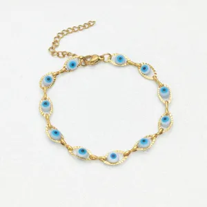 Dettaglio di un braccialetto in acciaio dorato con perline blu dell'occhio del male.