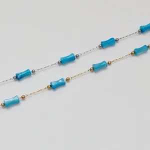 Detailed view of turquoise bamboo beads on gold and silver stainless steel chains