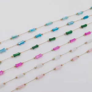 Detailed macro view of colorful bamboo-shaped acrylic beads on gold stainless steel chains