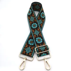 Detalle de la correa étnica de jacquard con motivos florales cian y hebillas doradas