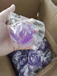 Detailed view of bulk purple bulb-shaped squishy toys packed in a cardboard box