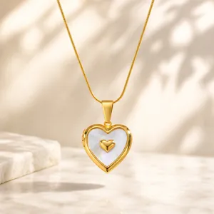 Detail view of gold heart locket necklace with mother-of-pearl inlay and thin chain