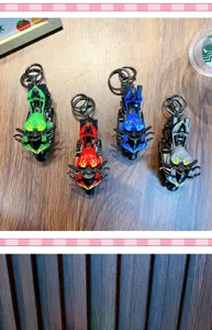 Set of four colorful flame motorcycle toy keychains displayed on a wooden surface