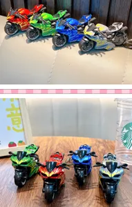 Detailed view of colorful flame patterned alloy motorcycle toy keychains on a wooden table