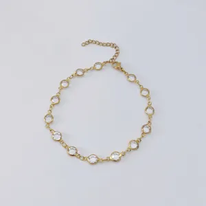 Exquisite detail of a gold stainless steel anklet with circular glass crystal insets