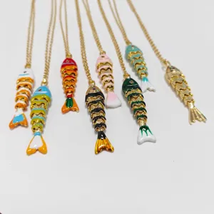 Primer plano de collares de peces articulados de colores con cadenas doradas vibrantes