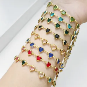 Detailansicht mehrerer bunter herzförmiger Glasgliederarmbänder, am Handgelenk getragen