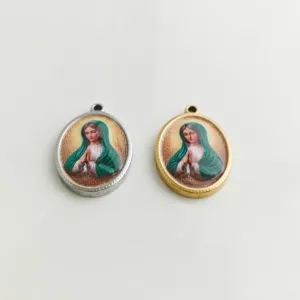 Primer plano de colgantes de retratos religiosos impresos en 3D en acero inoxidable