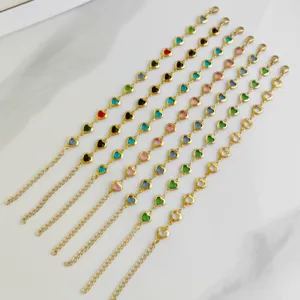 Close-up of colorful heart-shaped charms on gold-plated stainless steel chain bracelets.