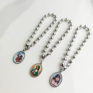 Detail of stainless steel beaded bracelets featuring religious portrait charms