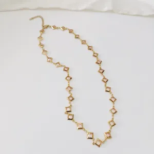 Detailed view of square rhombus crystal links on a gold stainless steel necklace