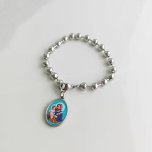 Detailed view of silver stainless steel beaded bracelet with a religious saint pendant
