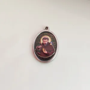 Close-up detail of stainless steel oval pendant with vintage religious saint portrait