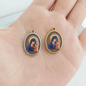 Detail of stainless steel religious oval pendants with Virgin Mary and Child portrait