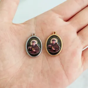 Close-up of vintage stainless steel religious pendants with Saint Francis image