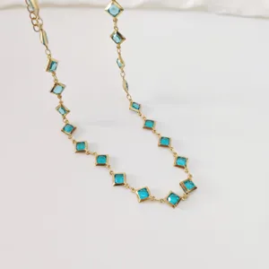 Macro shot of a stainless steel necklace featuring elegant diamond-shaped blue gems
