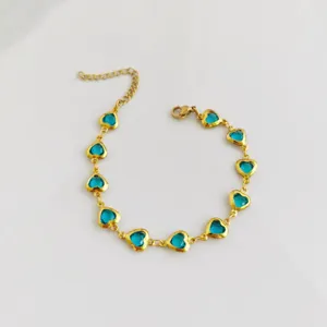 Detailed view of a gold stainless steel bracelet featuring blue heart-shaped crystals.