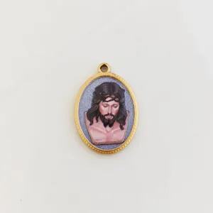 Detailed macro view of a golden oval Jesus pendant with 3D printed religious art