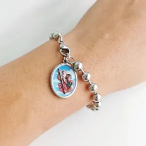 Close-up detail of stainless steel ball bracelet with Saint Christopher religious medal charm