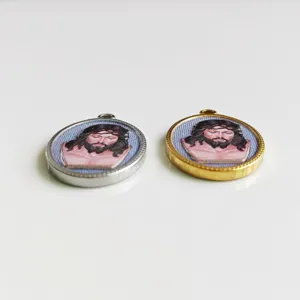Detail view of silver and gold stainless steel oval pendants with 3D printed Jesus icon