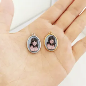 Detailed view of oval 3D-printed Jesus portrait pendants in gold and silver steel frames