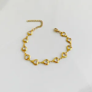 Detailed shot of a gold stainless steel heart bracelet with clear crystal stones.