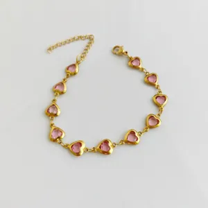 Detailed view of gold stainless steel bracelet with pink heart crystals