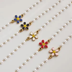 Detailed view of stainless steel imitation pearl bracelets featuring colorful enamel daisy charms