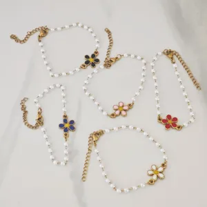 Multi-colored daisy charms on elegant faux pearl bracelets for a stylish look.