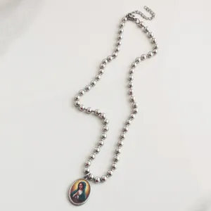 Gedetailleerd overzicht van zilveren roestvrijstalen kralenketting met Maagd Maria hanger